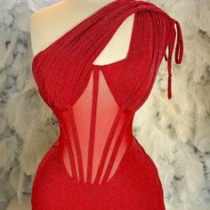 a mannequin wearing a red dress with sheer fabric