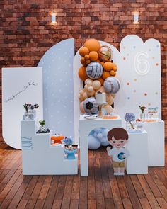 an assortment of balloons and decorations on display in front of a brick wall at a children's birthday party