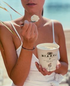 a woman eating ice cream on the beach