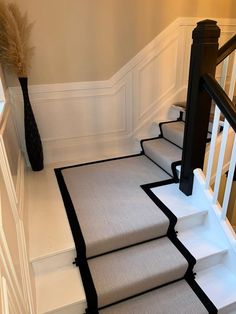 the stairs are lined with black and white carpet