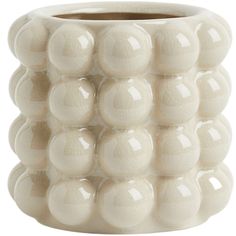 a white vase with many balls in it