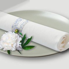 a white flower and napkin on a plate