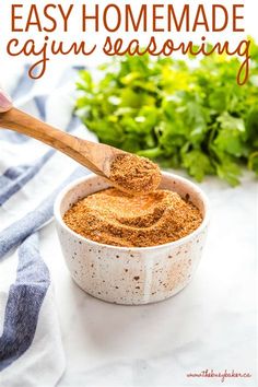 homemade cajun seasoning in a white bowl with a wooden spoon and parsley on the side