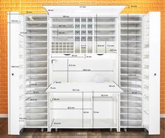 the closet is full of white drawers and shelving units with measurements for each drawer