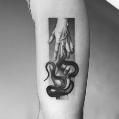 a black and white photo of a person's arm with a snake on it