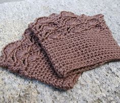 two brown knitted cloths sitting on top of a stone