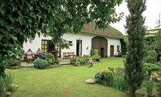 a small white house sitting on top of a lush green field