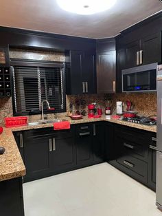 a kitchen with granite counter tops and black cabinets