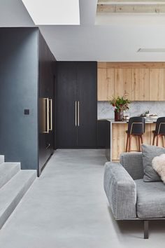 a living room filled with furniture next to a kitchen