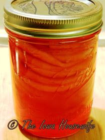 a jar filled with red liquid sitting on top of a wooden table