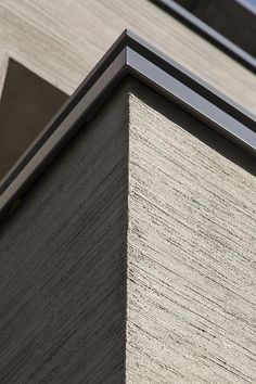 the corner of a building with a clock on it's face and sky in the background