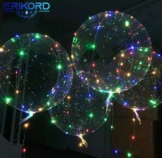 three clear balloons with multicolored lights on them