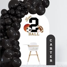 there is a balloon arch with balloons in the shape of numbers 2 and footballs on it