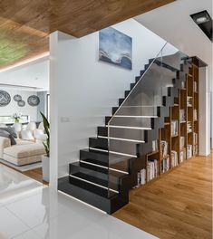 there is a staircase in the living room with bookshelves on each side and an open bookcase at the bottom