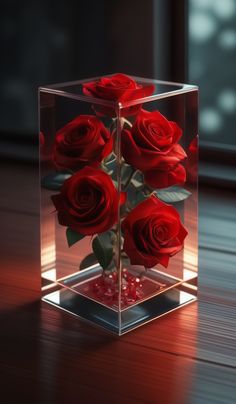 red roses in a square glass vase on a wooden table