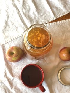 an apple cider and some apples on a table