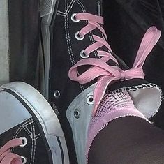 a pair of black and pink shoes with laces on the bottom are sitting next to each other