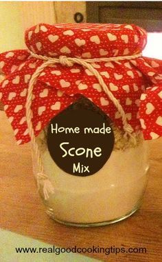 a jar filled with some white and red hearts sitting on top of a wooden table