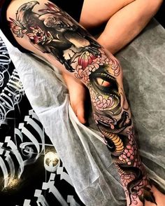 a woman's leg with tattoos on it and an eye in the middle of her leg