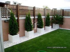 an outdoor area with artificial grass and potted plants in front of a fence that says interest