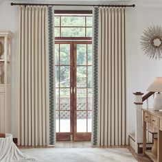 a living room with white walls and curtains