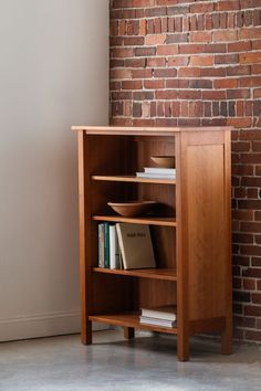 a bookshelf in front of a brick wall with a book case on it