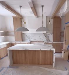 an unfinished kitchen with marble counter tops and wooden cabinets