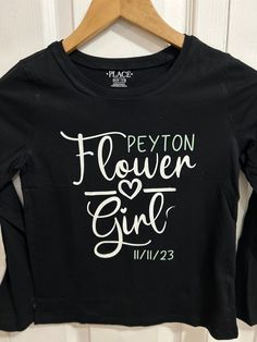 Youth flower girl long sleeved tshirt  Comes in black or white with your choice of name and date color  Perfect for getting ready or a flower girl gift Don't see what you're looking for? We love to do custom orders, message me with the details!  ⭐️ Every item is made with ♥️, customized to your liking  ⭐️ NO CANCELLATIONS.... please read each listing carefully  ⭐️ Handmade items may take longer to ship, please notify me of any time constraints! ⭐️ All customized items are printed to order especially for you & are a FINAL SALE  ⭐️ Please message me with any questions before purchasing, We are here to answer any questions you might have! DELIVERY TIMES ⭐️ Although we cannot guarantee specific delivery dates, feel free to message us for other expedited shipping options. ⭐️ PLEASE PLACE ORDERS Flower Girl Tshirt, Bridal Party Hangers, Flower Girl Shirts, Cheerleading Mom, Preschool Shirts, Wedding Party Shirts, Design Your Own Shirt, Bridal Party Shirts, Flower Girl Gifts