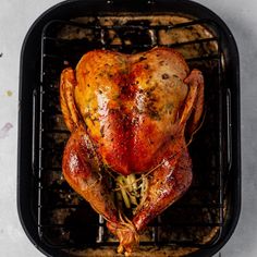 a roasted turkey on a grill with herbs