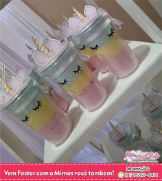 three cups with unicorn faces on them are sitting next to each other in front of a window