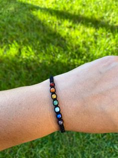 a person wearing a bracelet with multi colored beads