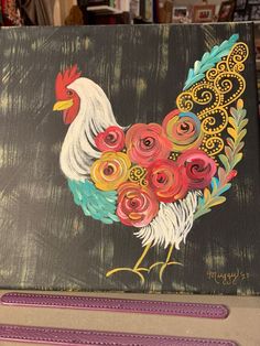 a painting of a rooster with flowers on it's tail and feathers painted on the side