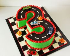 a birthday cake that is shaped like the number three with cars around it on a checkered board