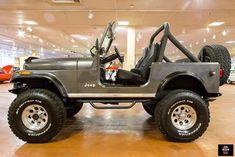 a jeep is parked in a showroom with other cars