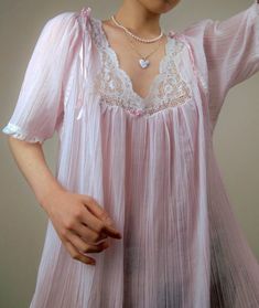 A delicate vintage pastel pink nightgown by designer, Christian Dior - Dainty lace and ribbon detailing along the neckline, sleeves, and hem - Entire gown is constructed from a delicate, pleated, and sheer plisse cotton blend fabric - Era: Circa 1970s - Condition: Excellent - Size: Medium - Color: Pastel pink, white Measurements: - 21.5in pit to pit - 53in garment length - 12.5 sleeve length Fabric Content: - 65% polyester, 35% cotton Shown on a mannequin with a 33" bust, 26" waist, and 35" hips. Fits a size 2-4. Model is 5'5 with a 34A bust. Some garments may be clipped onto mannequin or model for display. Thank you for visiting! Visit my official website, ariessencebyariel.com, for more! Vintage Bustier, Pink Nightgown, Vintage Hollywood Glamour, Vintage Christian Dior, Color Pastel, Women's Nightgowns, Pretty Lingerie, Nightgowns, Fashion History