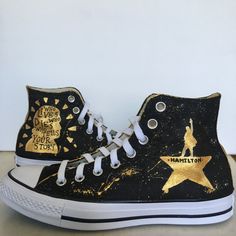 a pair of black and gold painted converse sneakers