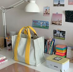 a white and yellow bag sitting on top of a desk next to a light fixture