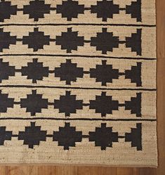 a black and white rug on top of a wooden floor