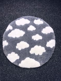 a black and white rug with clouds on it in the middle of dark carpeted area