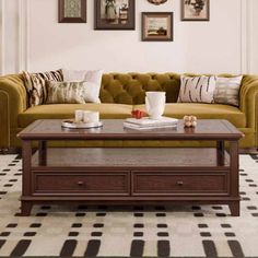 a living room with couches, coffee table and pictures on the wall above it