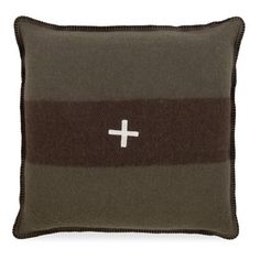 a brown and black pillow with a cross on the front, sitting on a white background