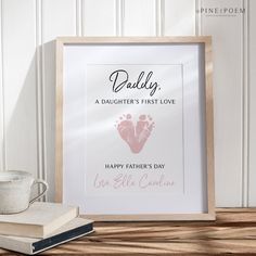 a father's first love print is displayed in front of a book and cup