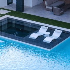 an empty swimming pool with lounge chairs and artificial grass in the back yard, as seen from above