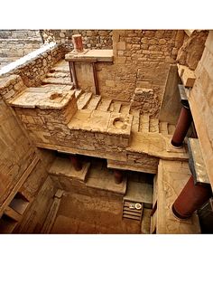 an aerial view of the interior of a building with stone stairs and brick walls,