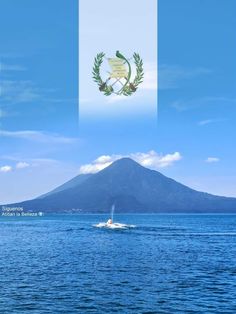 a boat is in the water with a flag on it's side and a mountain in the background