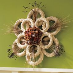 a decorative flower made out of rope on a green wall