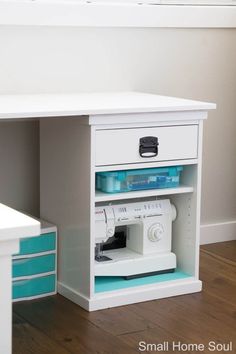 a white sewing machine sitting on top of a wooden table next to a desk with drawers