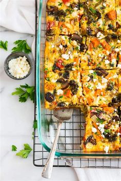 a glass casserole dish filled with vegetables and cheeses on a cooling rack