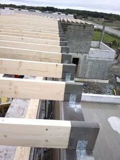 the roof is being built on top of an unfinished building with wooden beams sticking out of it