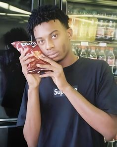 a young man holding a bag of food in front of his face